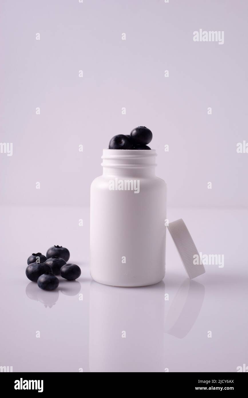 blueberry pills in white bottle on white background Stock Photo Alamy