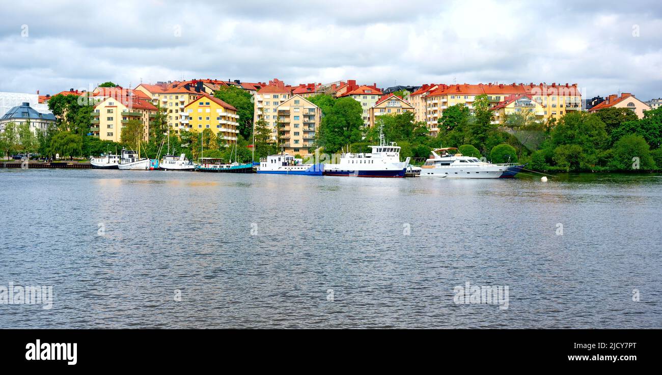 house facades and boats at the embankment of the watercourse Mariebergsfjärden in Stockholm Stock Photo