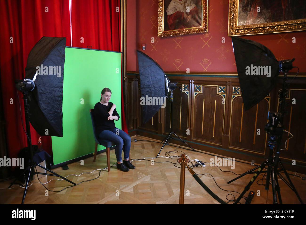 Cracow. Krakow. Poland. Female sign language interpreter works in front of the camera with the greenbox background behind her. Stock Photo