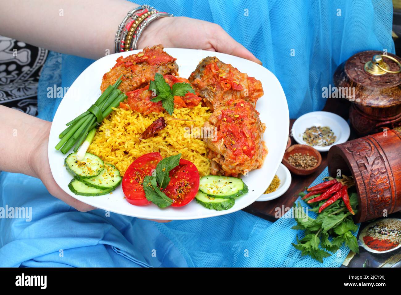 Female hands holding a plate of fried fish and basmati rice Stock Photo
