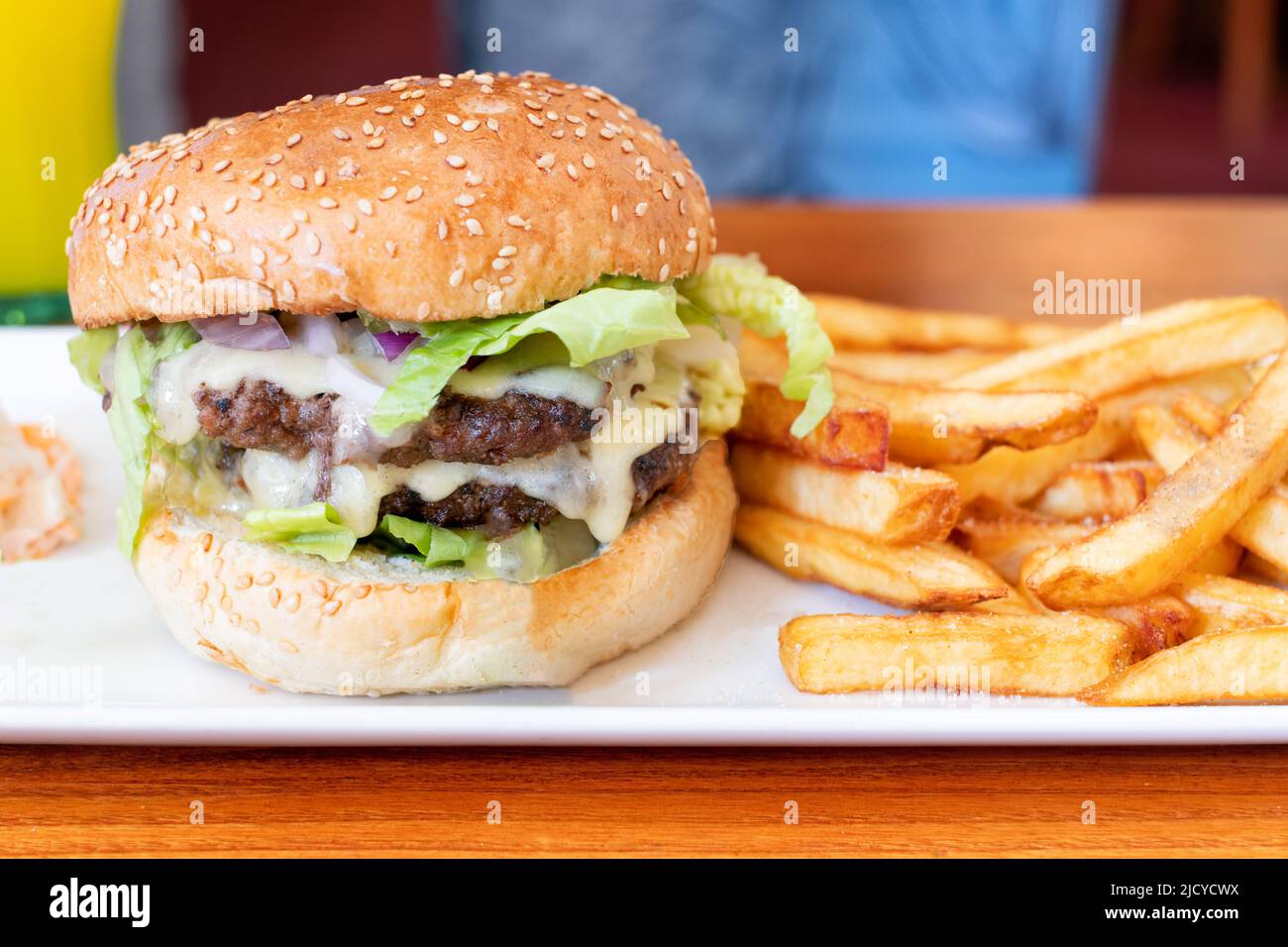 A Brewers Fayre Big stack Burger served in one of the chains uk restaurants with french fries. A tasty but high calorie meal option Stock Photo