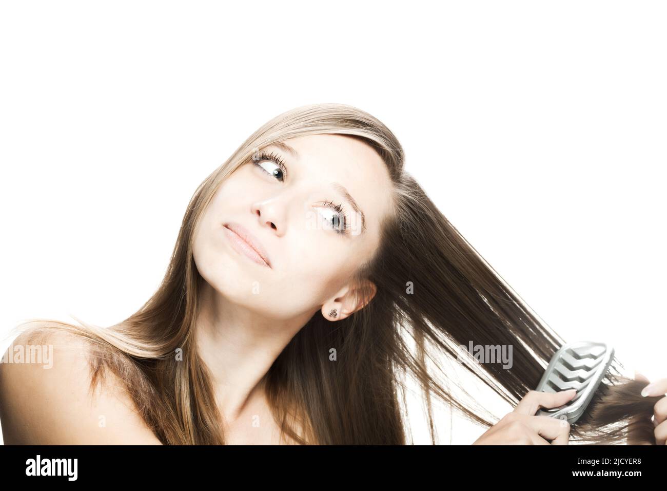 Studio portrait of a beautiful brunette girl combing her hair against