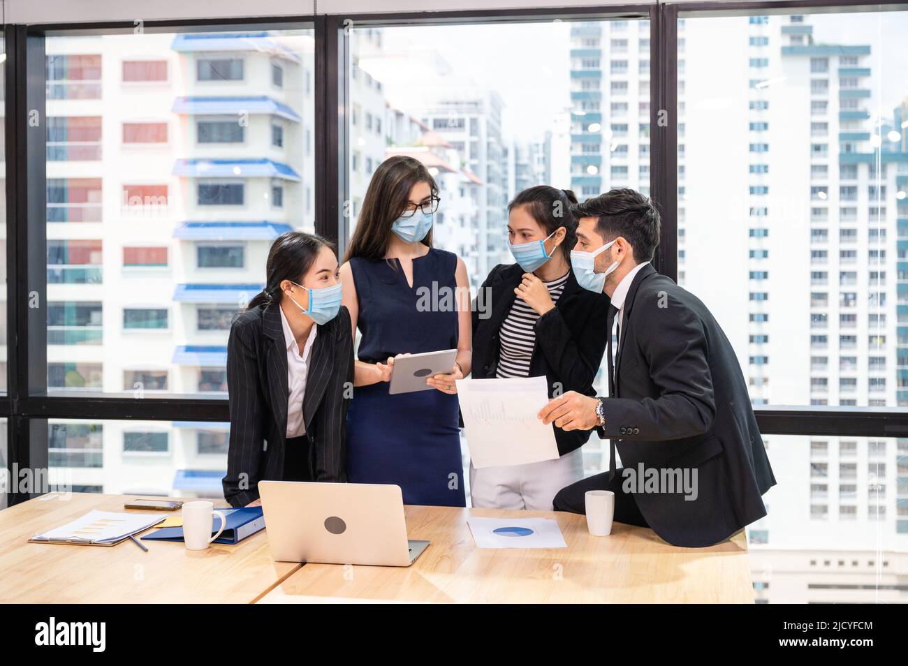 Multiethnic business team wearing face mask during business meeting in ...