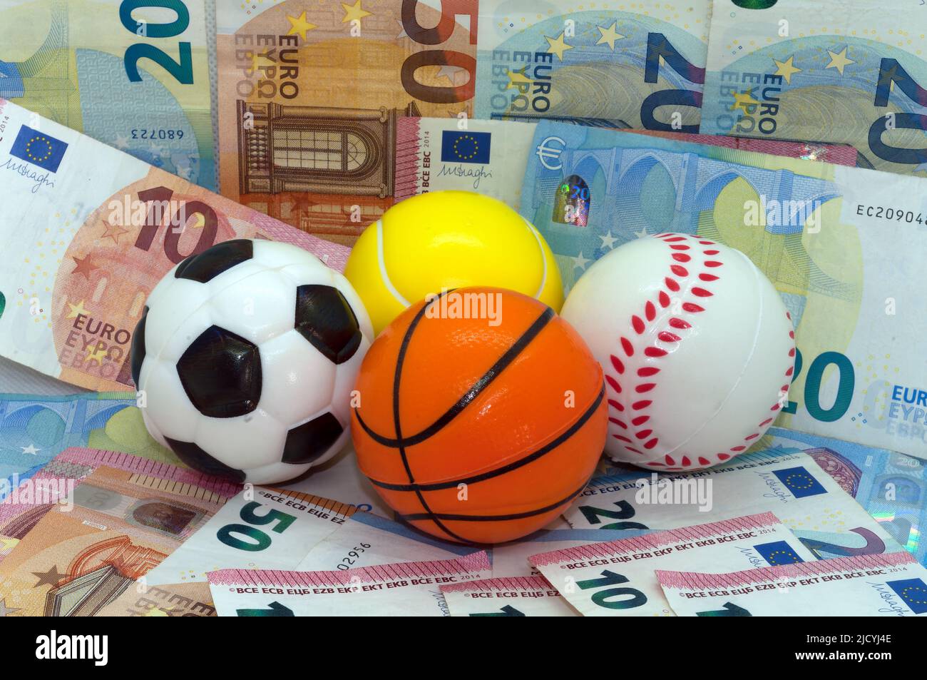 Symbol image: sport and money, balls against a background of banknotes Stock Photo