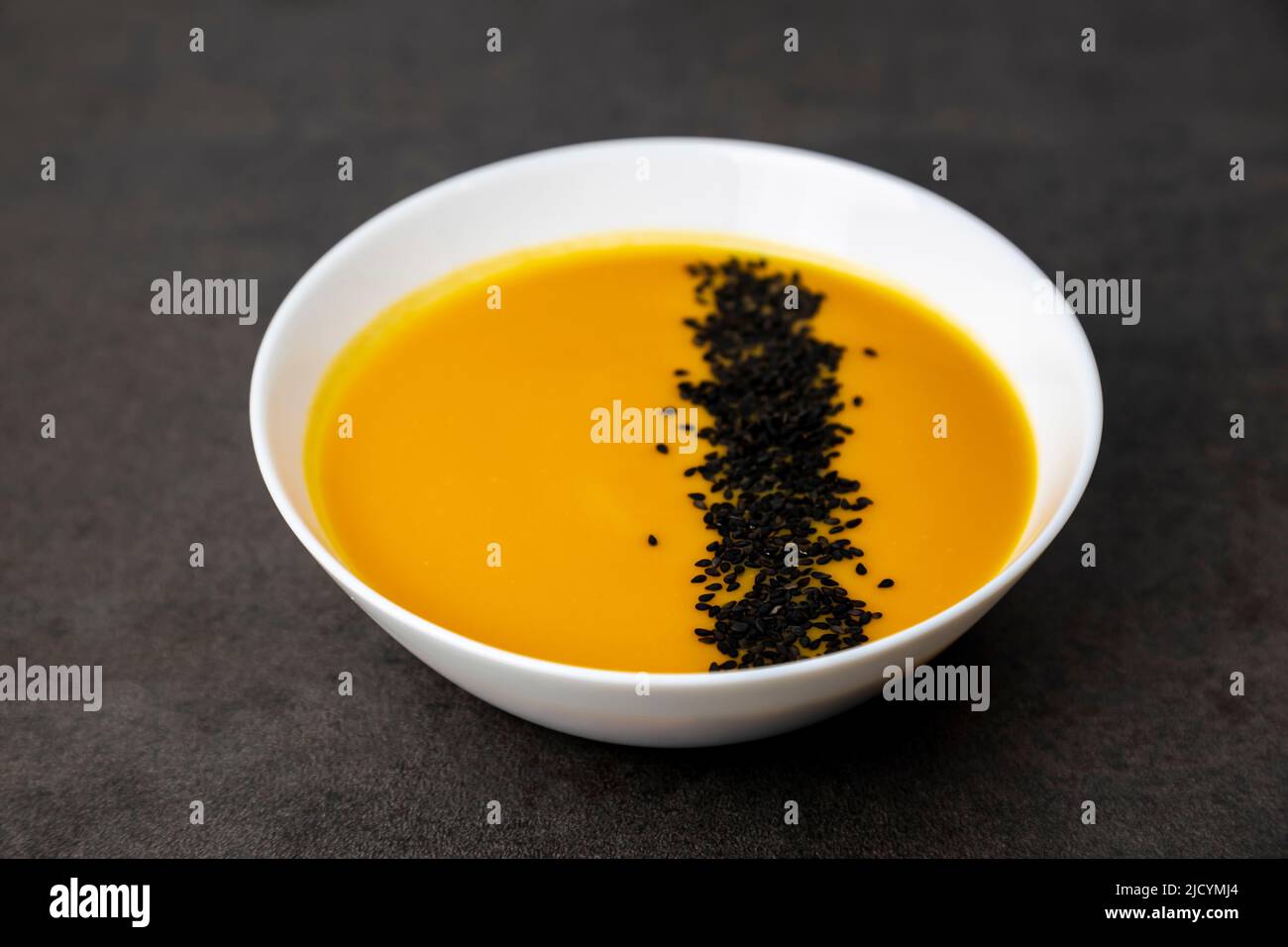 Pumpkin soup sprinkled with black sesame seeds. Healthy food. Stock Photo