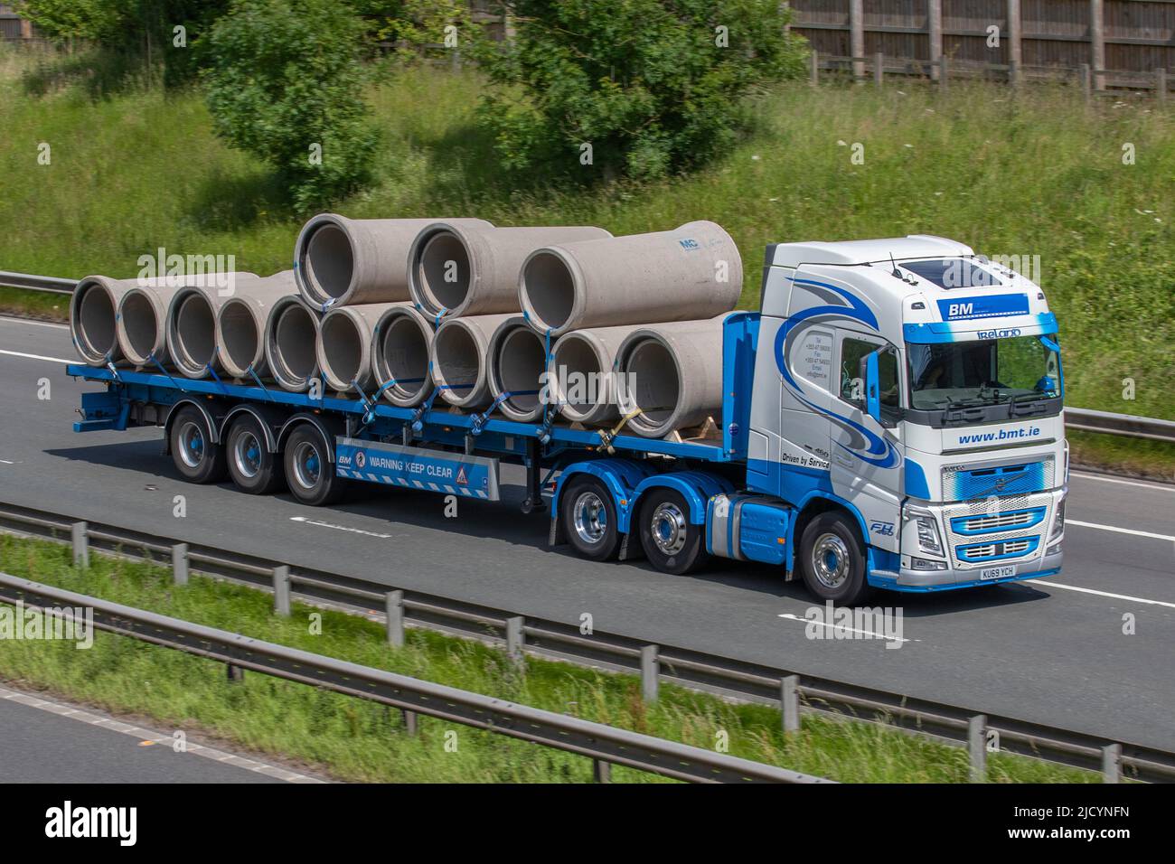 B & M Transport; Haulage flat bed truck driving on the M6 Motorway, Manchester, UK Stock Photo