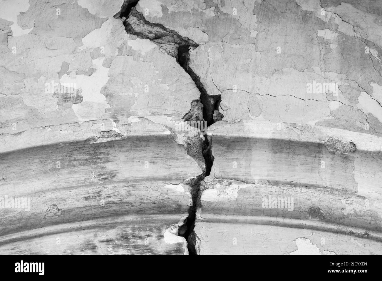 Big winding crack in arched structure, abstract image of vertical cleft. Black and white photo. Close-up. Copy space. Selective focus. Stock Photo