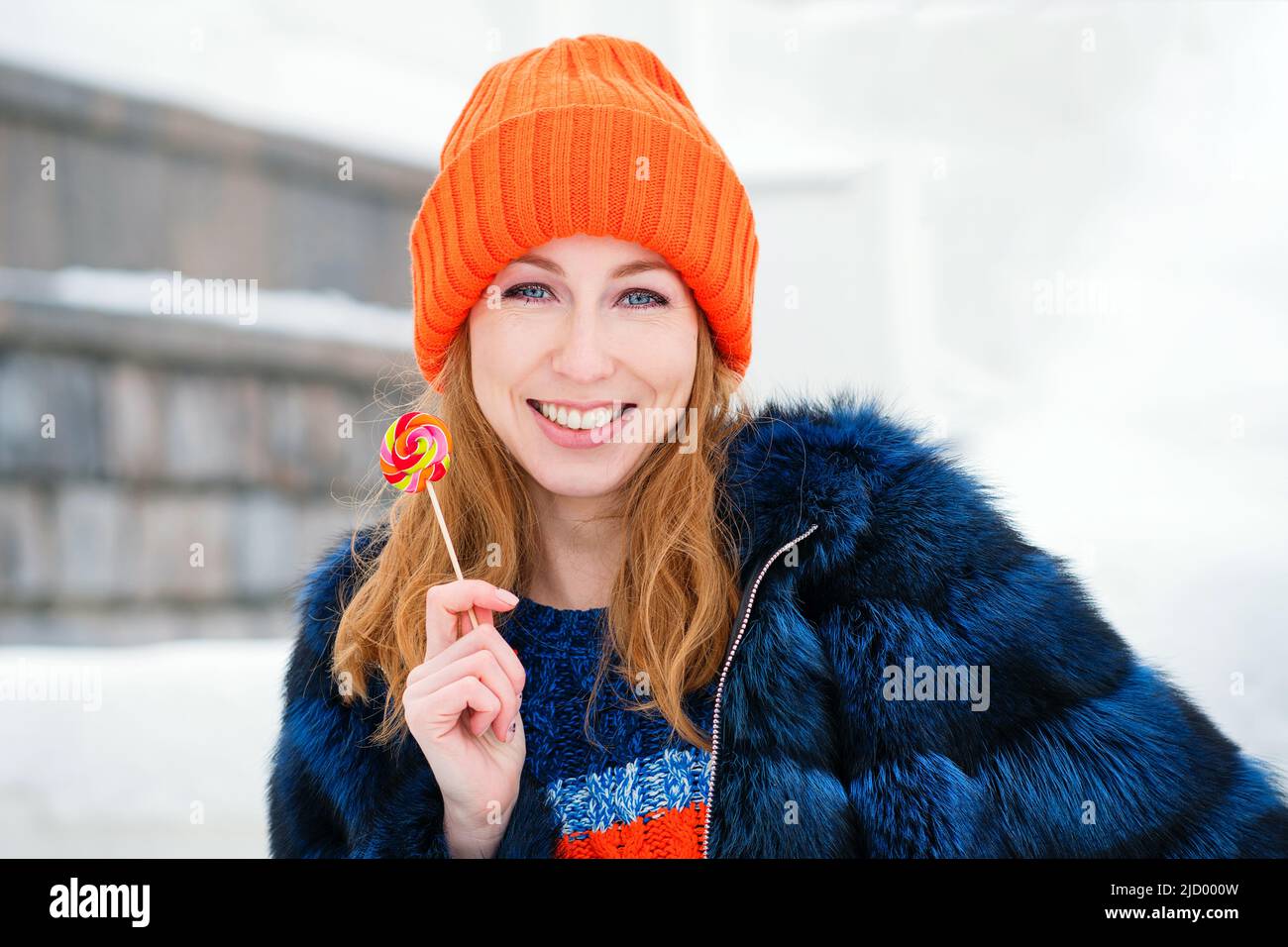 Portrait Attractive Girl Walking in Winter Park. Young Woman in Stylish  Warm Outfit and Orange Beanie Hat Holds Lollipop in Hand Outdoors. Enjoying  Ca Stock Photo - Alamy