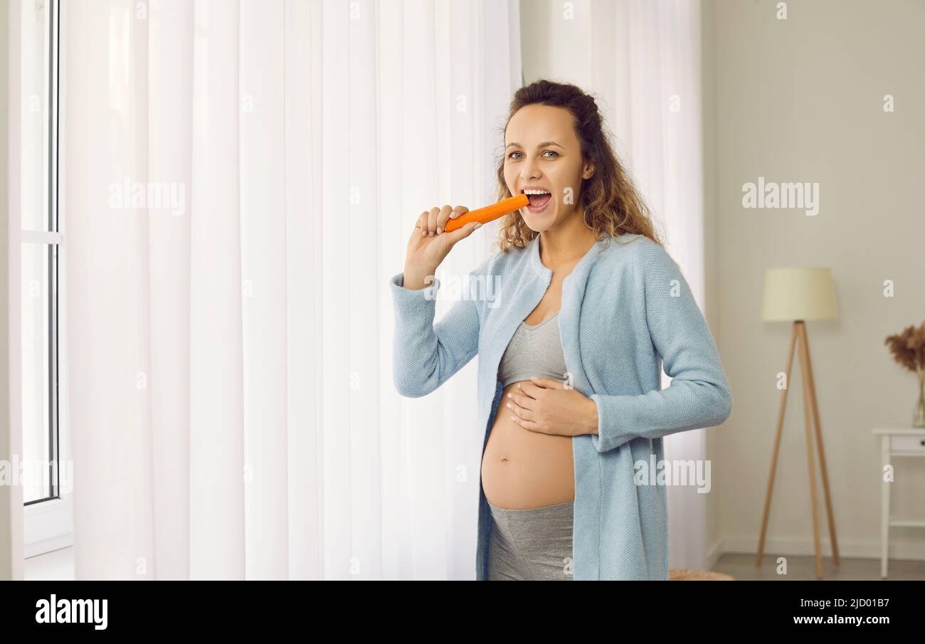 Smiling pregnant woman eat vegetables Stock Photo