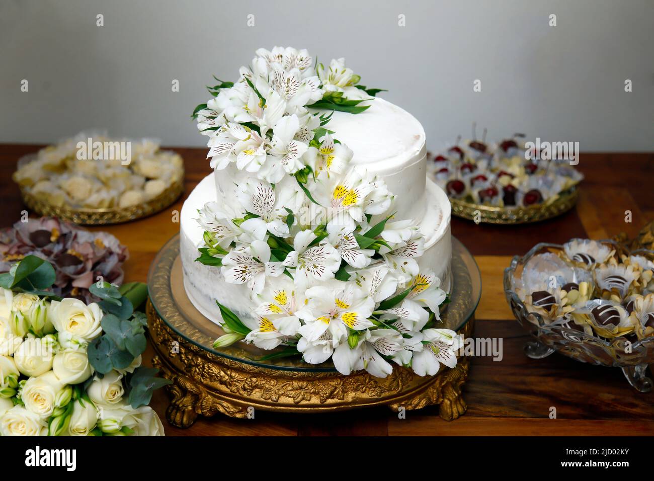 beautiful white color wedding cake in two layers decorated with astromelia flowers Stock Photo
