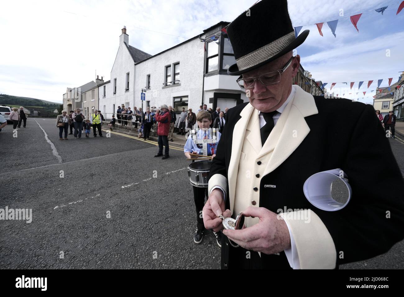 Selkirk, UK. 16th June, 2022. Selkirk, UK., . Selkirk Common Riding 2022. Thursday, The Night afore the Morn. Senior Burgh Officer, Mr Graeme Bell checking his watch before the start of the ceremonies, led by the Flute band, preambles the streets starting in the West Port, at 1830hrs, stopping at significant junctions while walking a circuit of the Market Place, High Street, Back Row, Kirk Wynd for the 'Crying of the Burley' ( Credit: Rob Gray/Alamy Live News Stock Photo