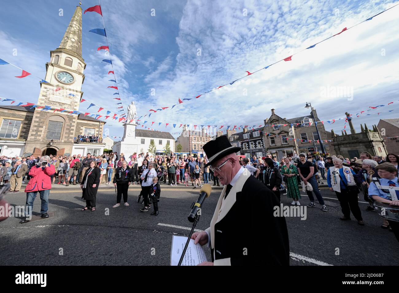 Selkirk, UK. 16.Jun.2022. Selkirk Common Riding 2022. Thursday, The Night afore the Morn. Senior Burgh Officer, Mr Graeme Bell led by the Flute band, preambles the streets starting in the West Port, at 1830hrs, stopping at significant junctions while walking a circuit of the Market Place, High Street, Back Row, Kirk Wynd for the “Crying of the Burley” and then onwards to the Victoria Halls, for the United Crafts Colour Bussin. At 2000hrs during the proceedings the Selkirk Ex-Royal Burgh Standard Bearers form up in a parade to march to the 'Fletcher Memorial' and lay a wreath and mark respec Stock Photo