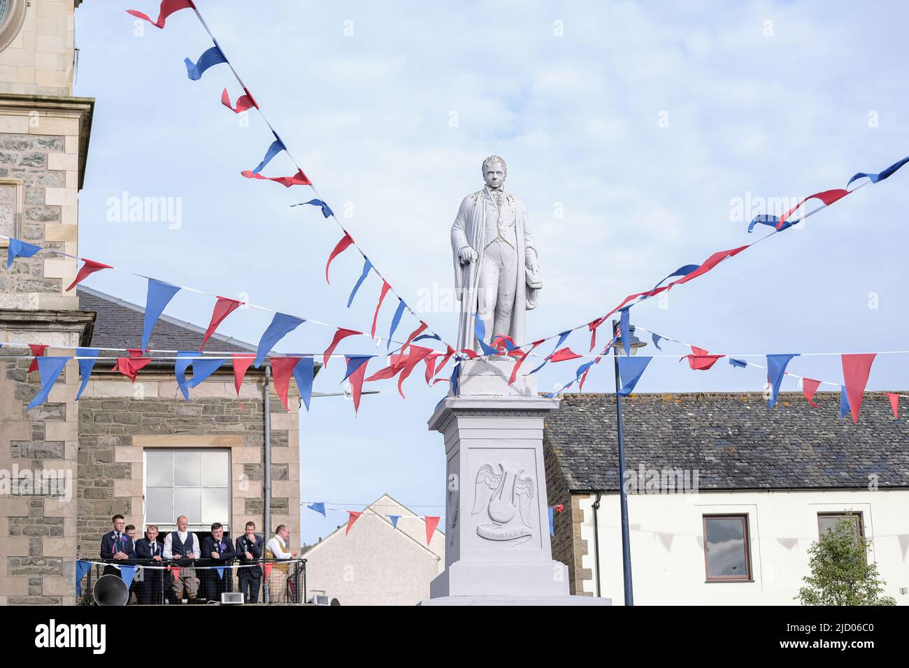 Selkirk, UK. 16.Jun.2022. Selkirk Common Riding 2022. Thursday, The Night afore the Morn. RBSB Nichol and his attendants look on from the Town Hall as Senior Burgh Officer, Mr Graeme Bell led by the Flute band, preambles the streets starting in the West Port, at 1830hrs, stopping at significant junctions while walking a circuit of the Market Place, High Street, Back Row, Kirk Wynd for the “Crying of the Burley” and then onwards to the Victoria Halls, for the United Crafts Colour Bussin. At 2000hrs during the proceedings the Selkirk Ex-Royal Burgh Standard Bearers form up in a parade to marc Stock Photo