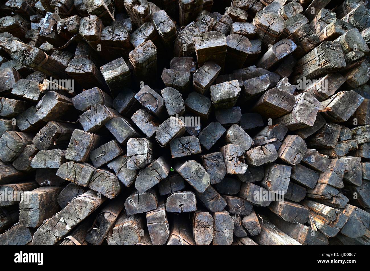 Larger piles of stacked used wooden railway sleepers. Wooden sleepers are better than other railway sleepers at absorbing the pressure. Stock Photo
