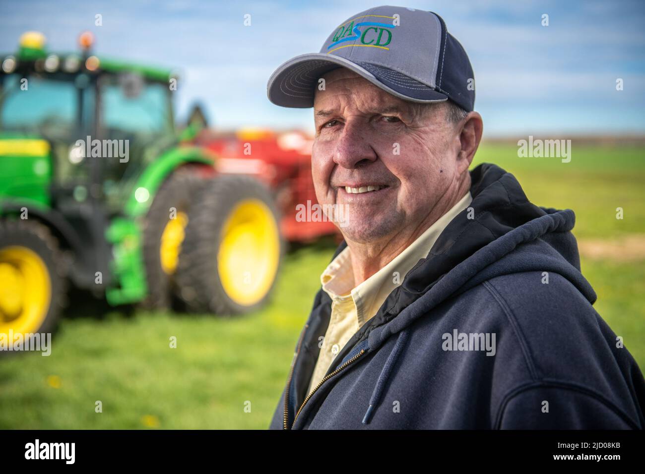Farmer in front of tractor Stock Photo - Alamy