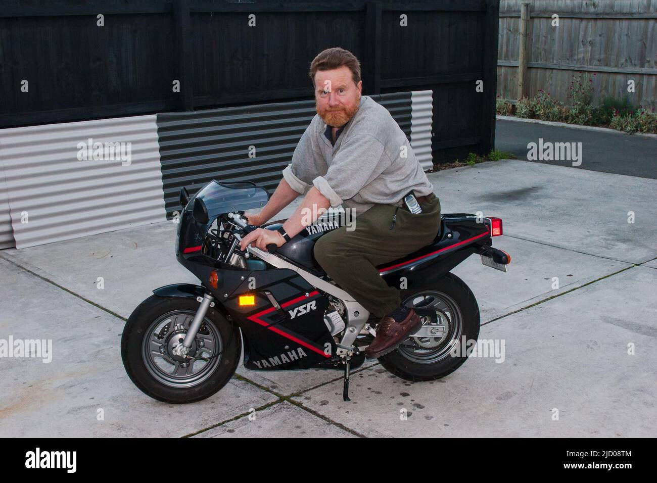 A look at life in New Zealand. Test-riding a little Yamaha YSR 50cc Motorcycle. Stock Photo