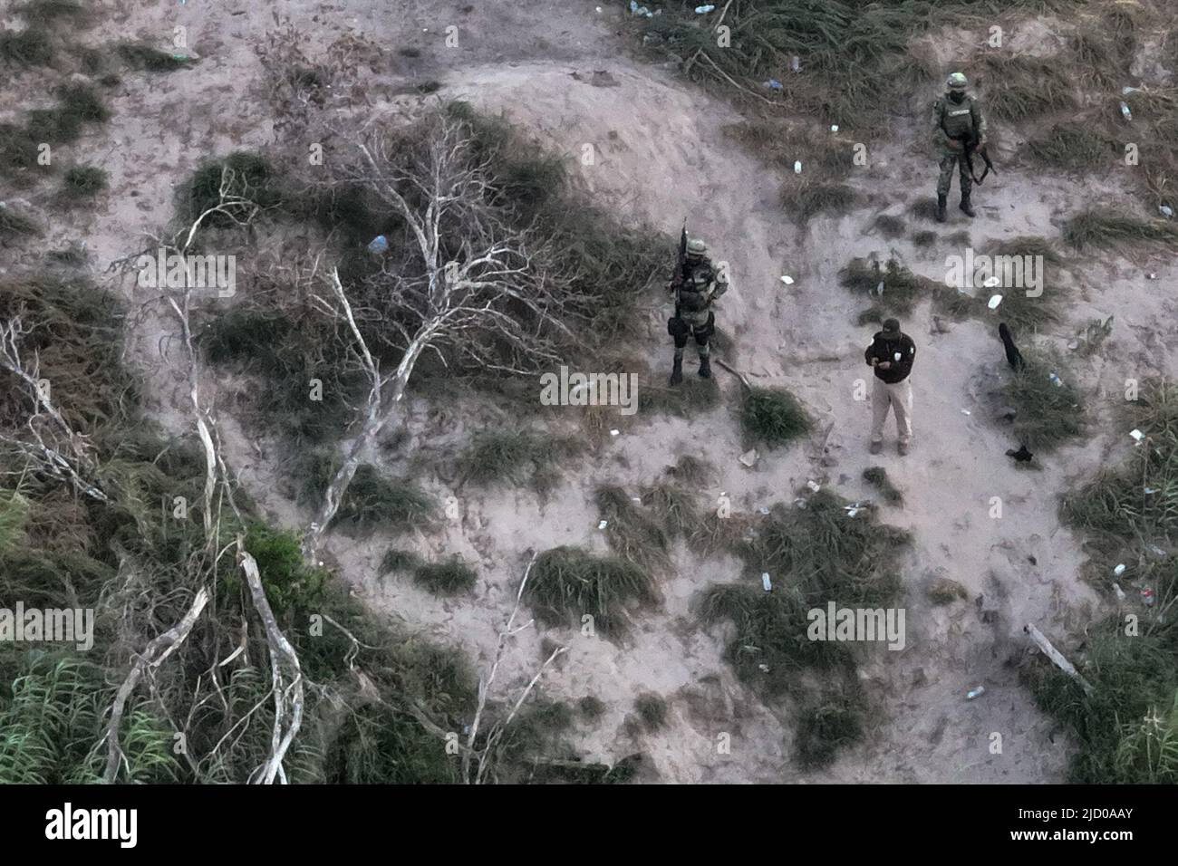 Mexican law enforcement personnel stand guard on trail used by migrant smugglers near the bank of the Rio Grande river, also known as the Rio Bravo, in Ciudad Miguel Aleman, Mexico as photographed from Roma, Texas, U.S., June 15, 2022. Picture taken with a drone on June 15, 2022.  REUTERS/Adrees Latif Stock Photo