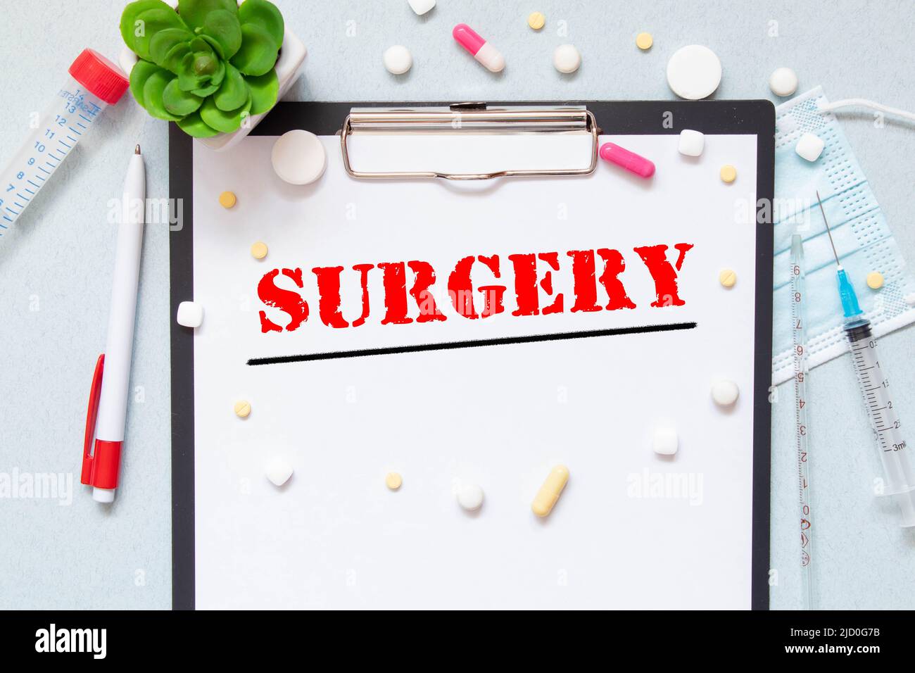 Stethoscope, pills and notebook with SURGERY word on medical desk Stock Photo