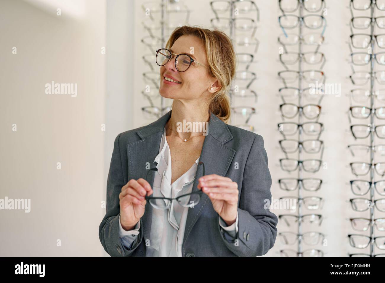 Businesswoman chooses a spectacle frame in an optician's shop Stock Photo