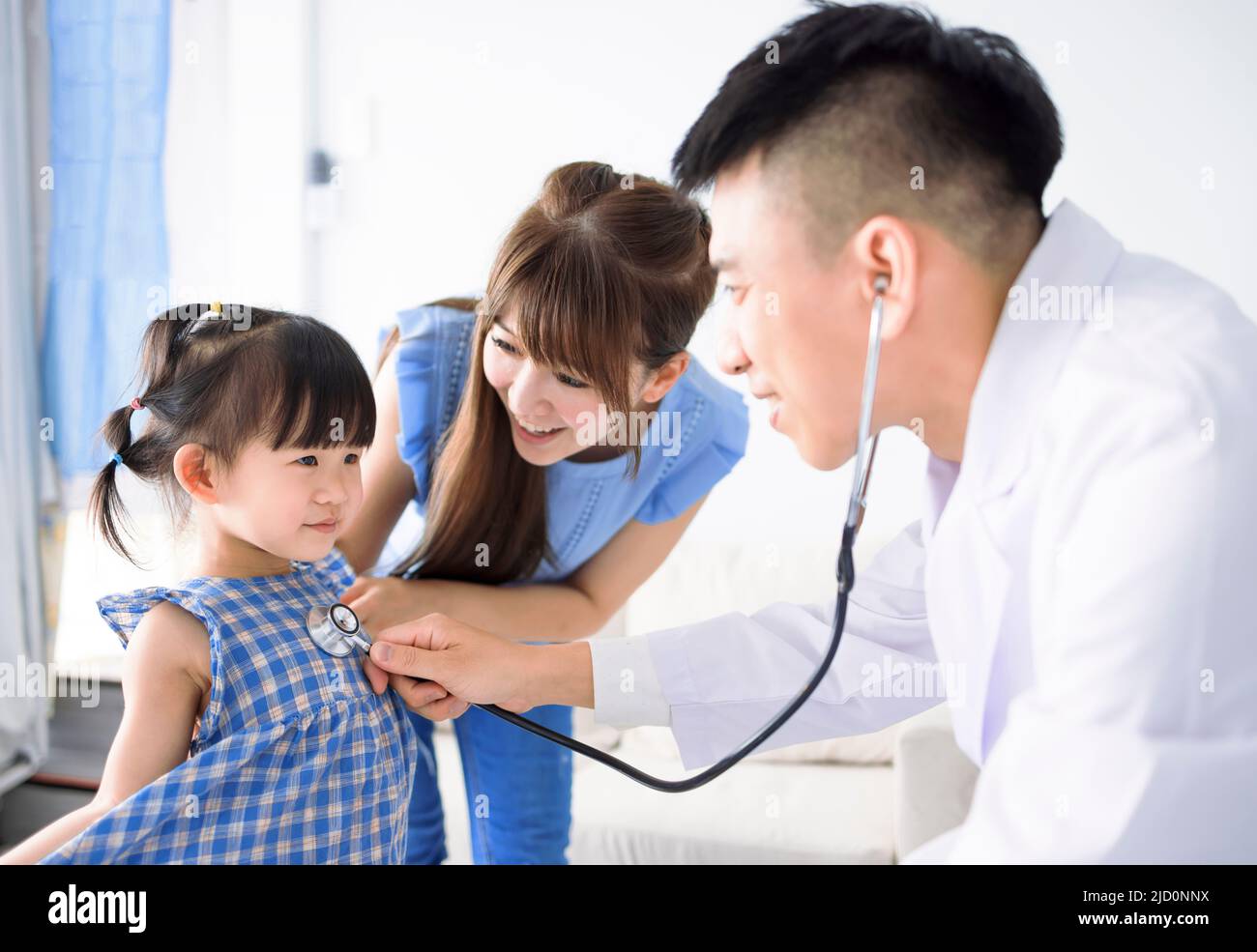 Male pediatrician hold stethoscope exam child girl patient visit doctor with mother Stock Photo