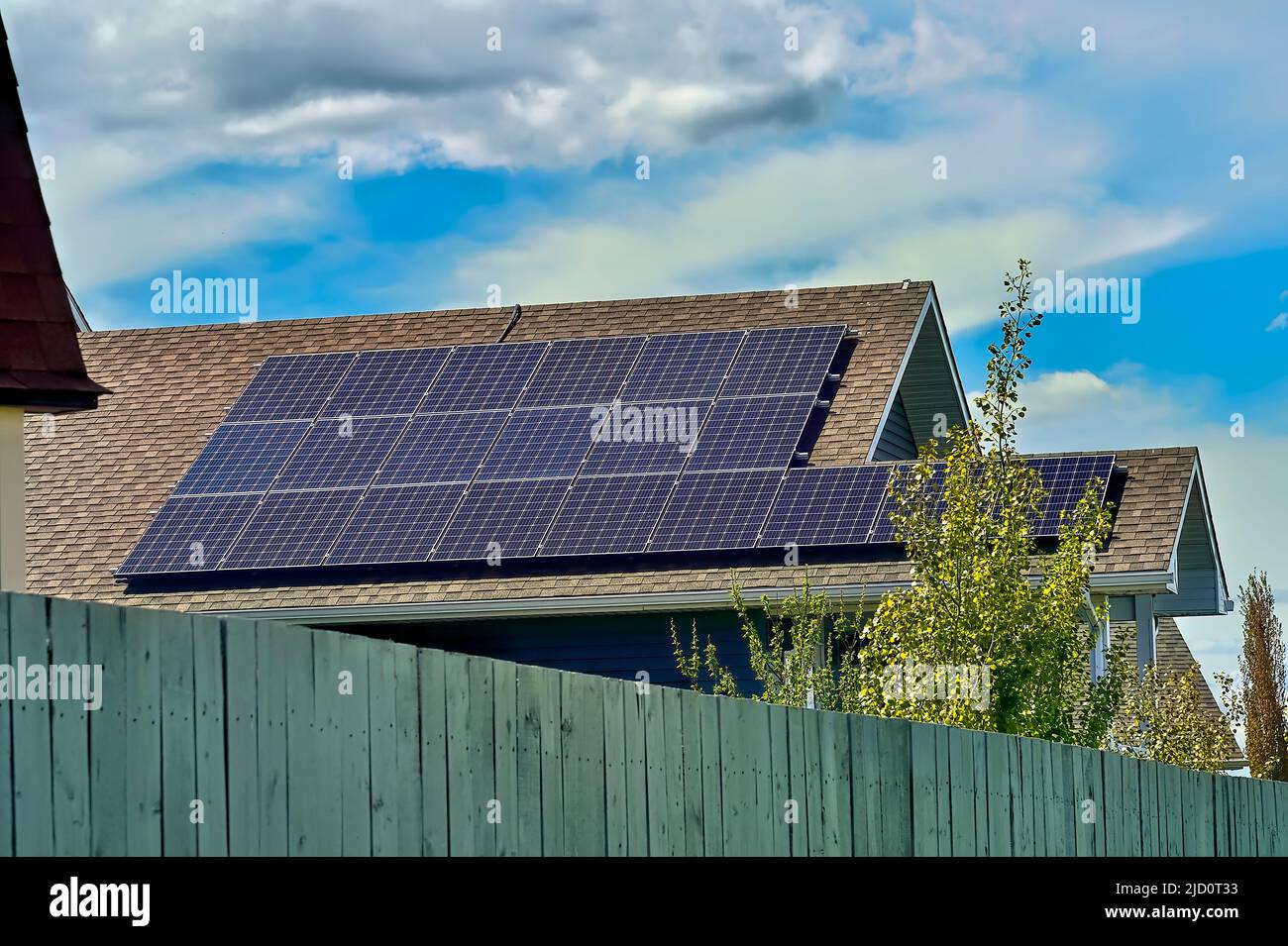 A row of solar panels placed on a house roof to gather the sun's light for energy to operate the house Stock Photo