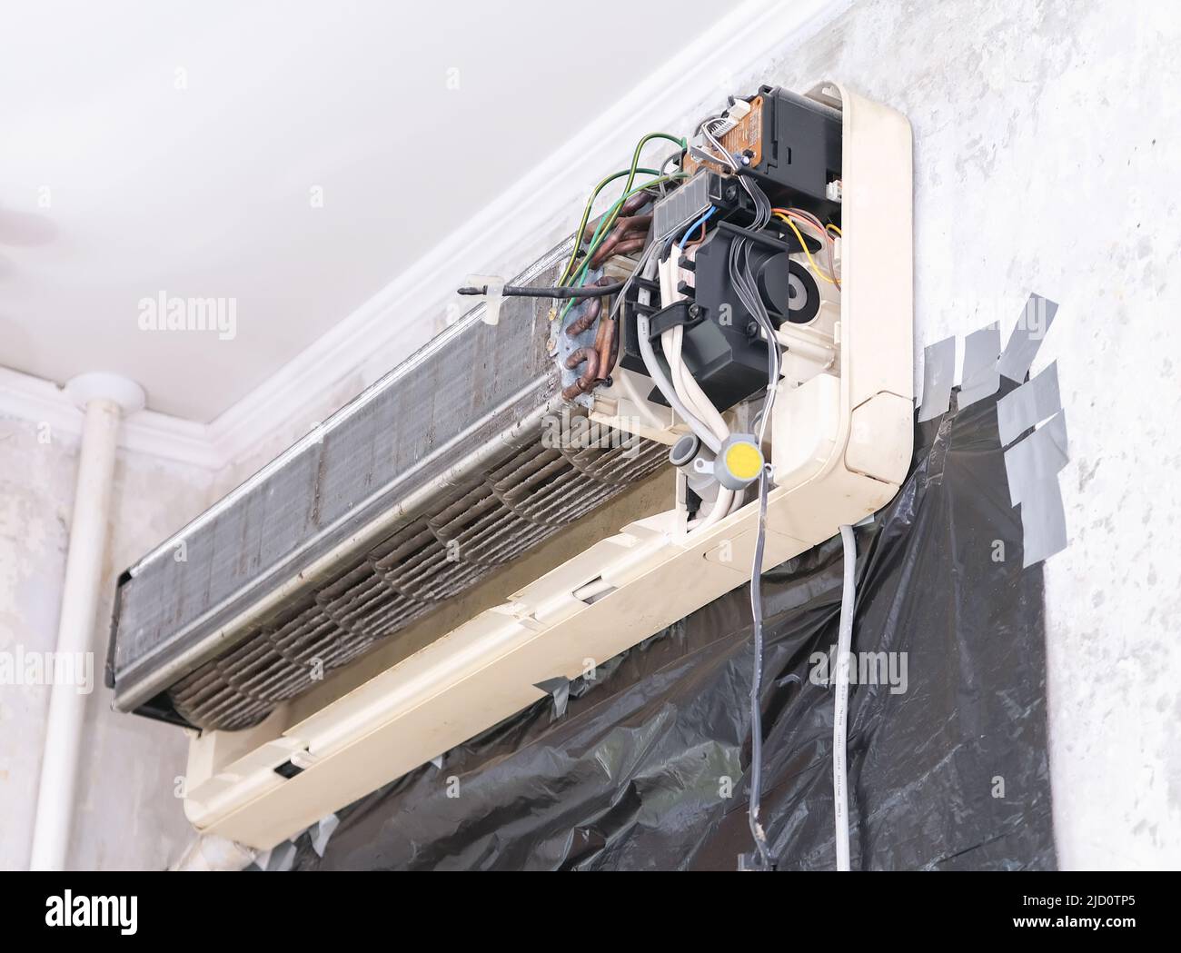 A man disassembles an air conditioner for cleaning. Split system