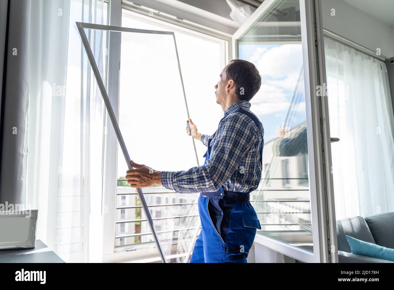 Mosquito Net Frame Install Service. Worker At Home Stock Photo