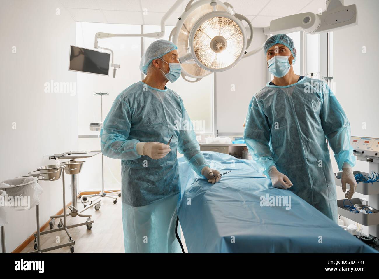Team of surgeons in the operating room ready for surgery in clinic waiting on patient Stock Photo