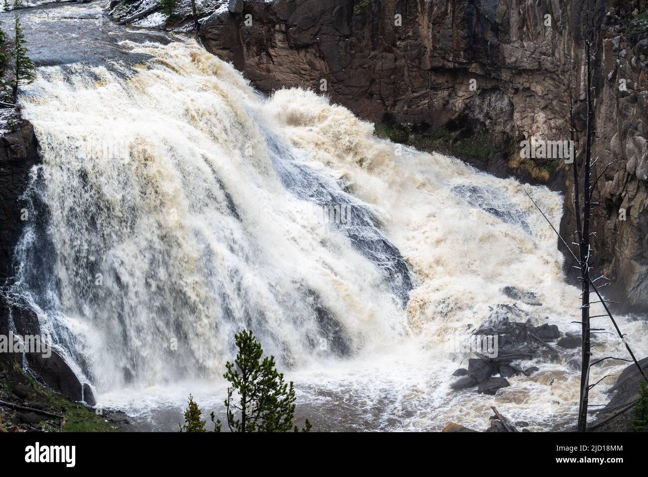 Rushing water over Gibbon Falls in Yellowstone National Park during a historic and dangerous flooding event. Stock Photo