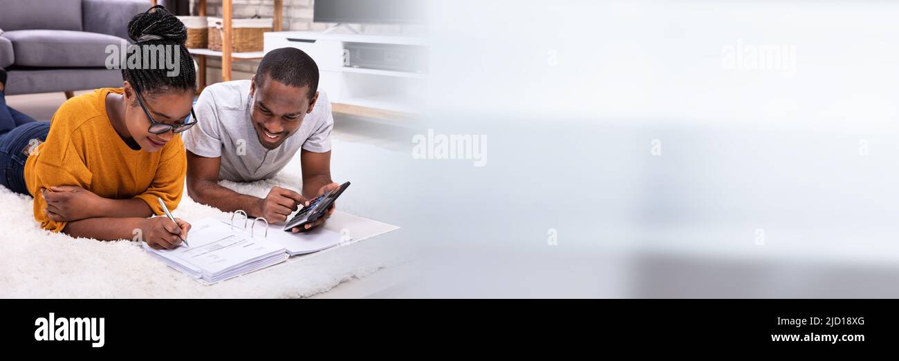 Young African Couple Lying On Carpet Invoice With Calculator Stock Photo