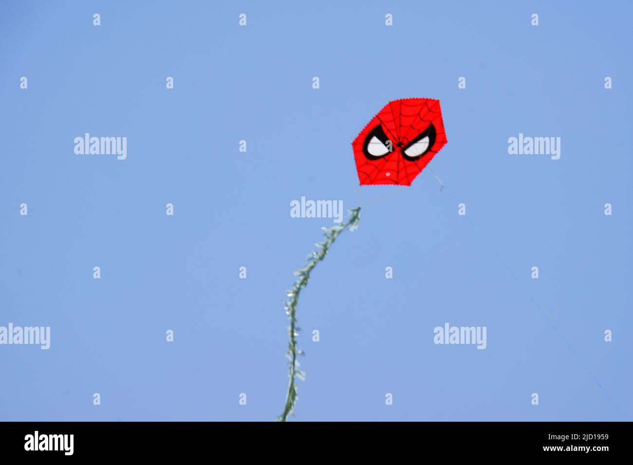Spider man shaped red kite at clear sky in a sunny summer day Stock Photo