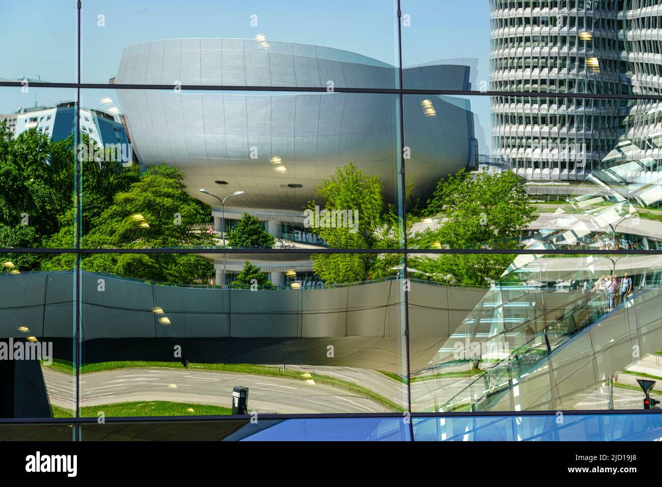 Reflections of the BMW Tower, BMW Museum and Trias Bridge in the glass facade of BMW World Munich, Germany, 15.5.22 Stock Photo