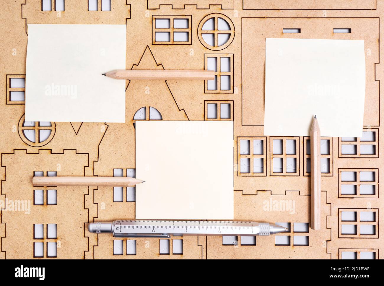 Plywood home model kit with paper notes, pen and pencils. House design