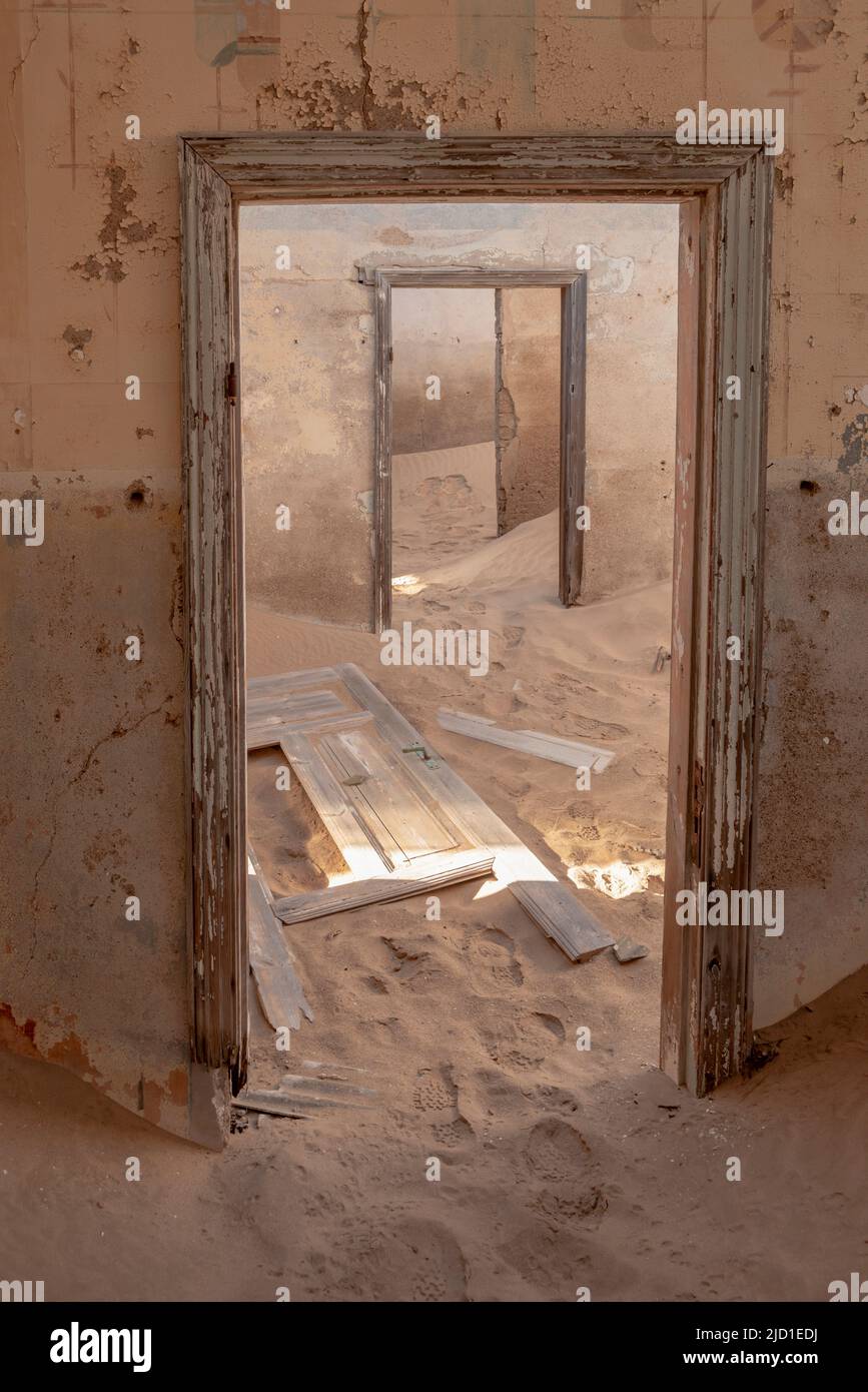 abandoned building interior with floor covered by desert sands from Kolmanskop town in Namibia Stock Photo