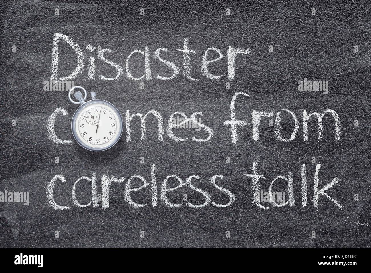 Disaster comes from careless talk Chinese proverb written on chalkboard with vintage precise stopwatch Stock Photo