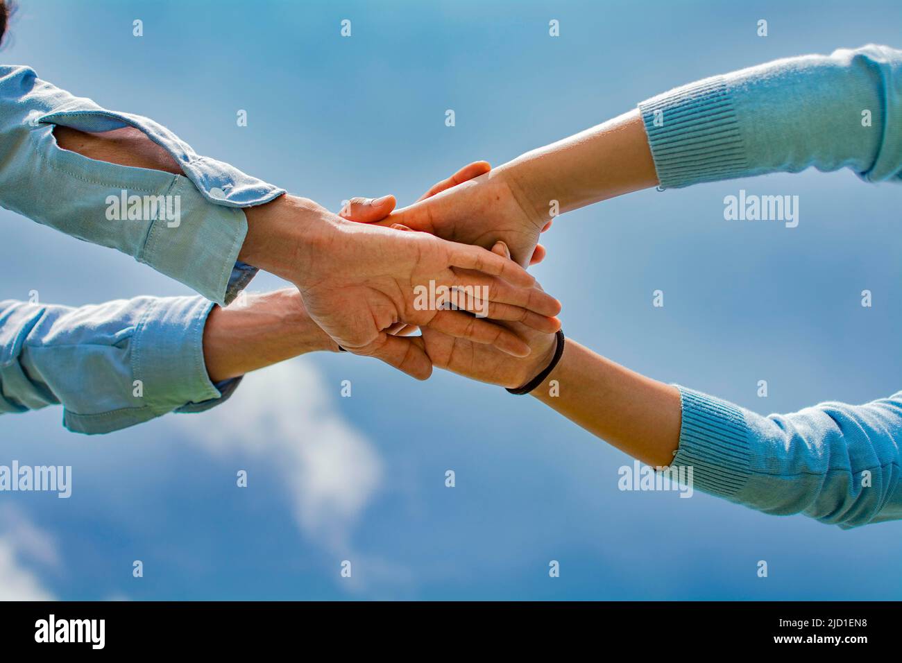 Concept of one hand over another forming a team, Concept of unity with the hands, palms together all for one and one for all, hands crossed in a Stock Photo