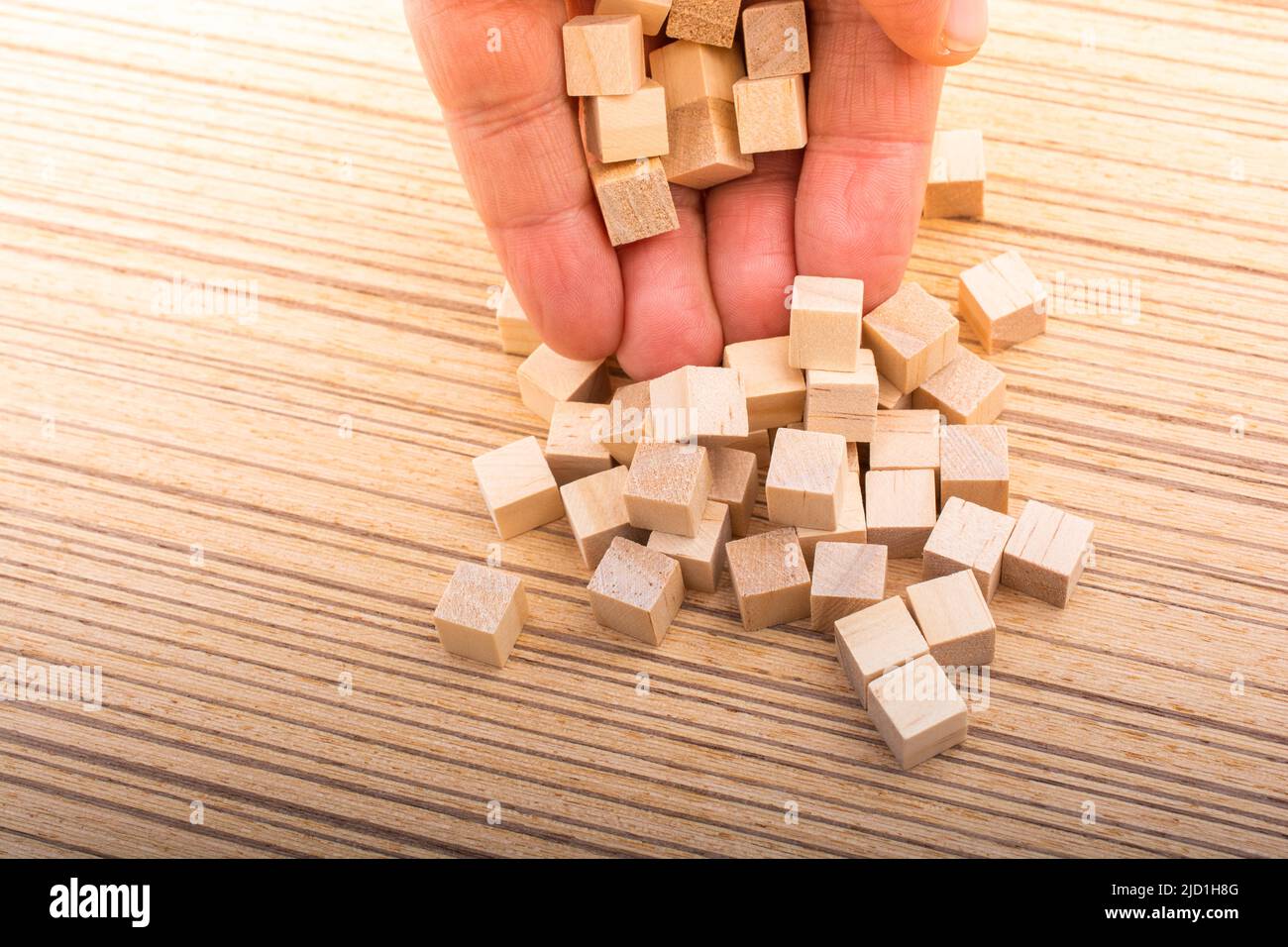 Hand playing with wooden cubes as educational and business concept Stock Photo