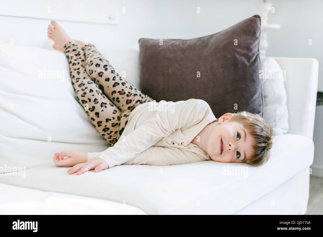 Smiling boy lying on sofa Stock Photo