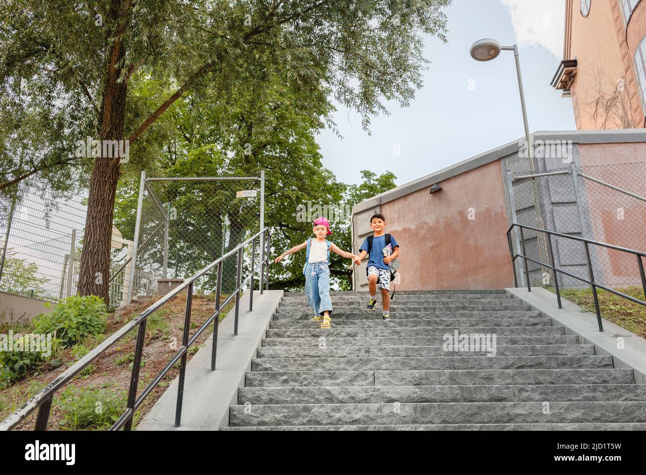 Children holding hands and walking down stairs Stock Photo Alamy