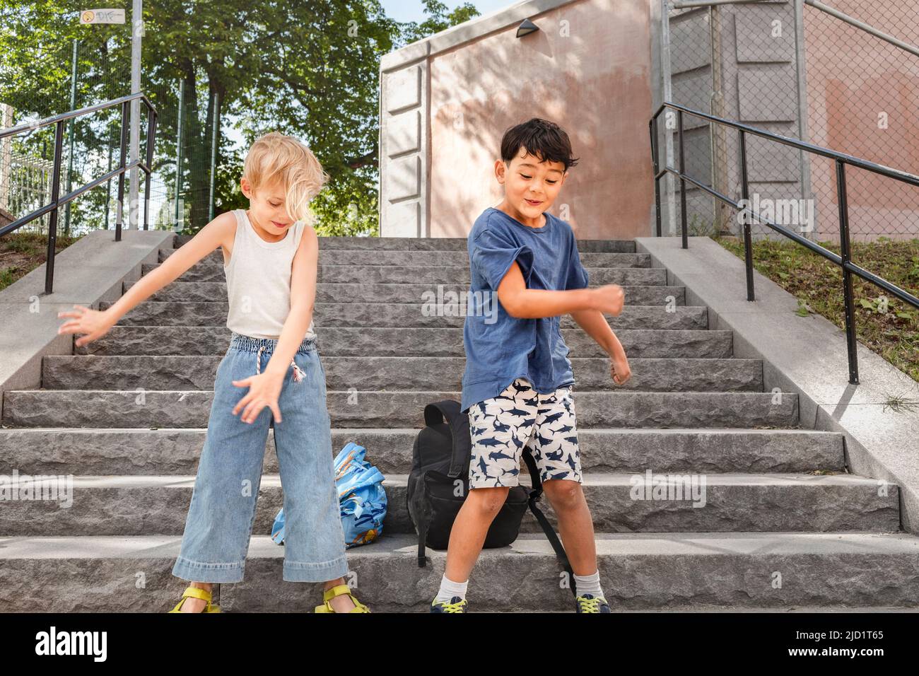 Children dancing on stairs in summer Stock Photo