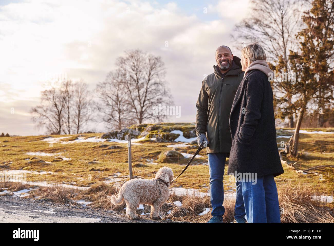 Couple walking with dog Stock Photo - Alamy