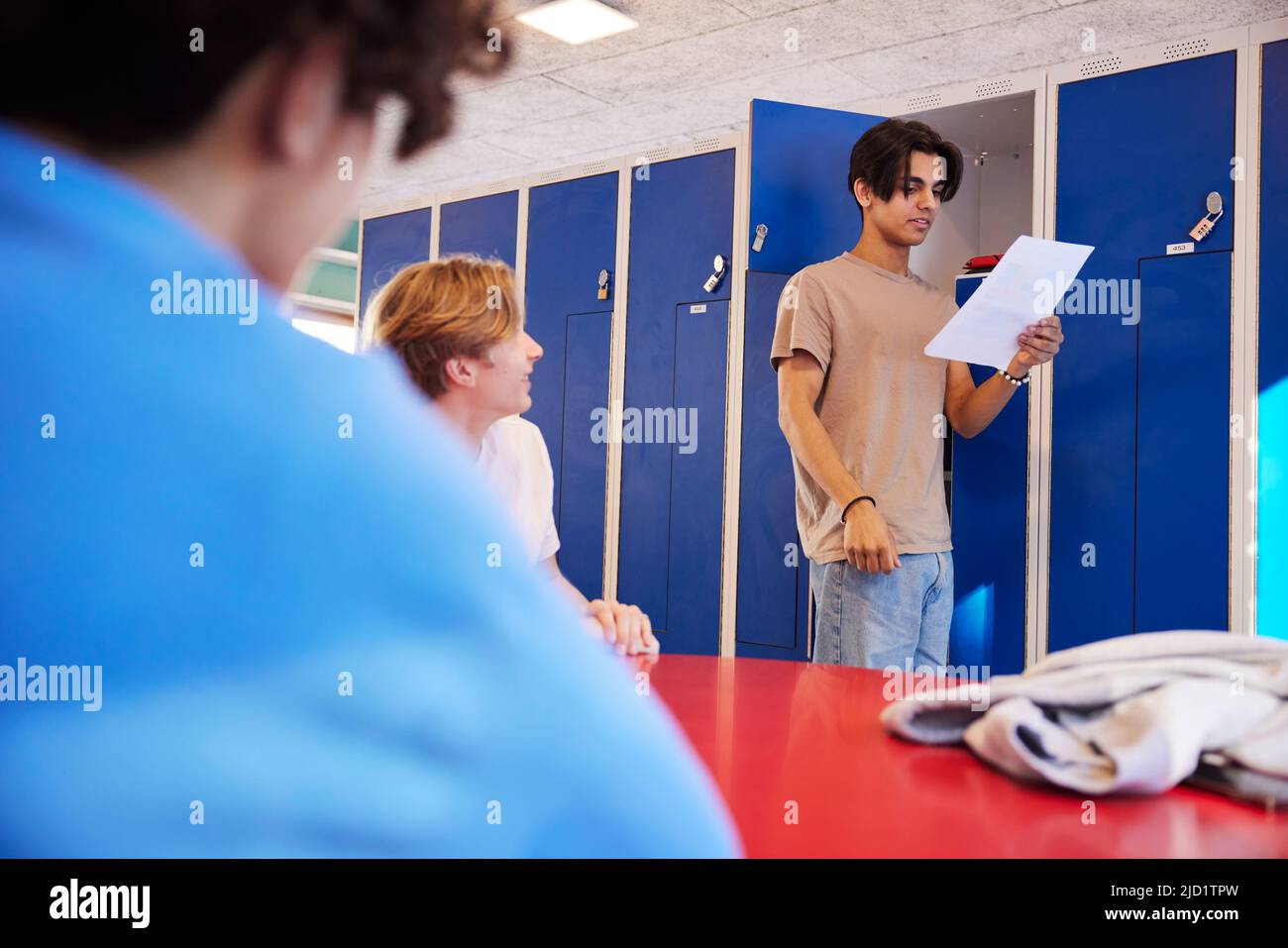 Teenage boys talking in locker room Stock Photo