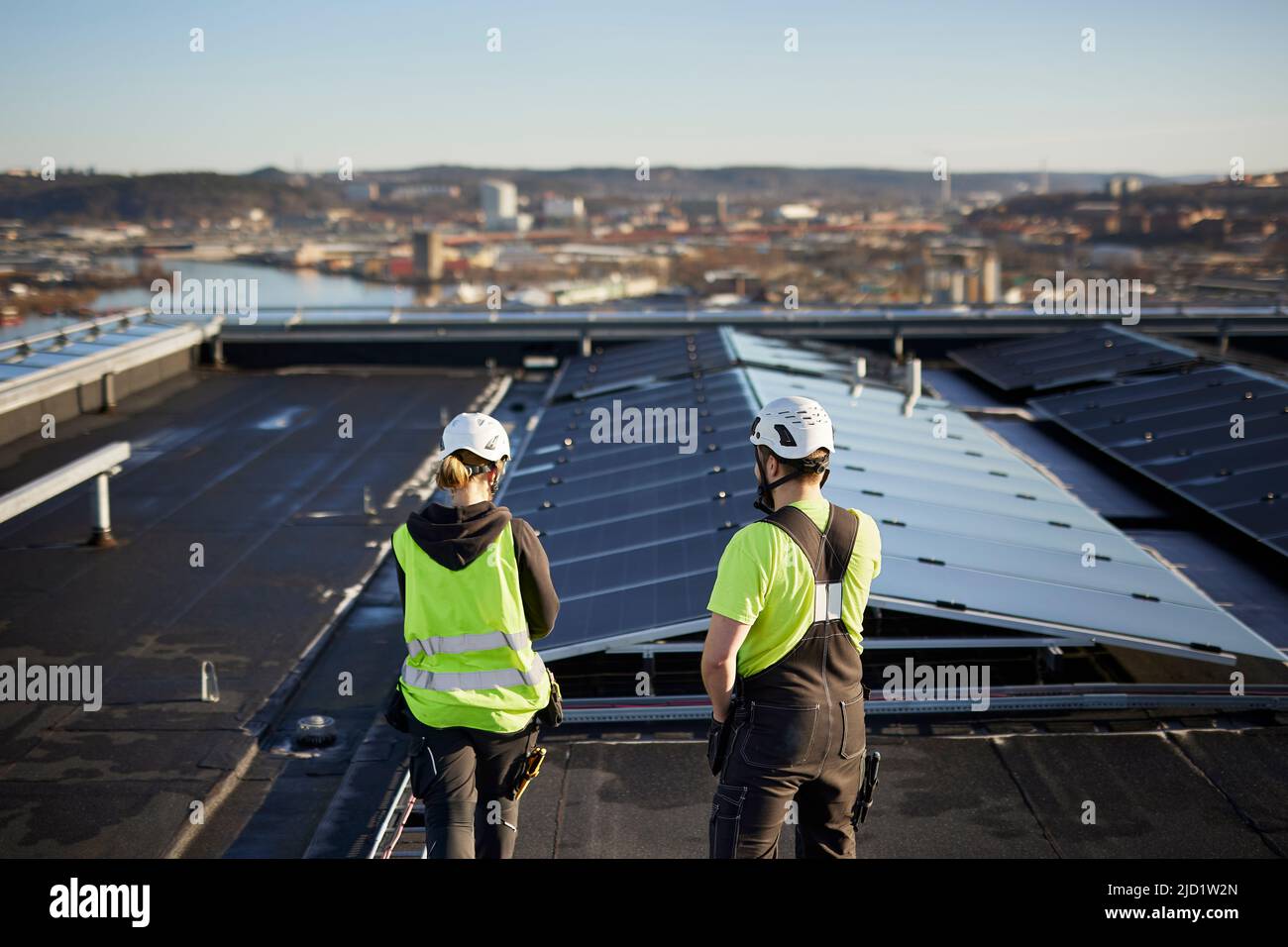 Workers standing on roof Stock Photo