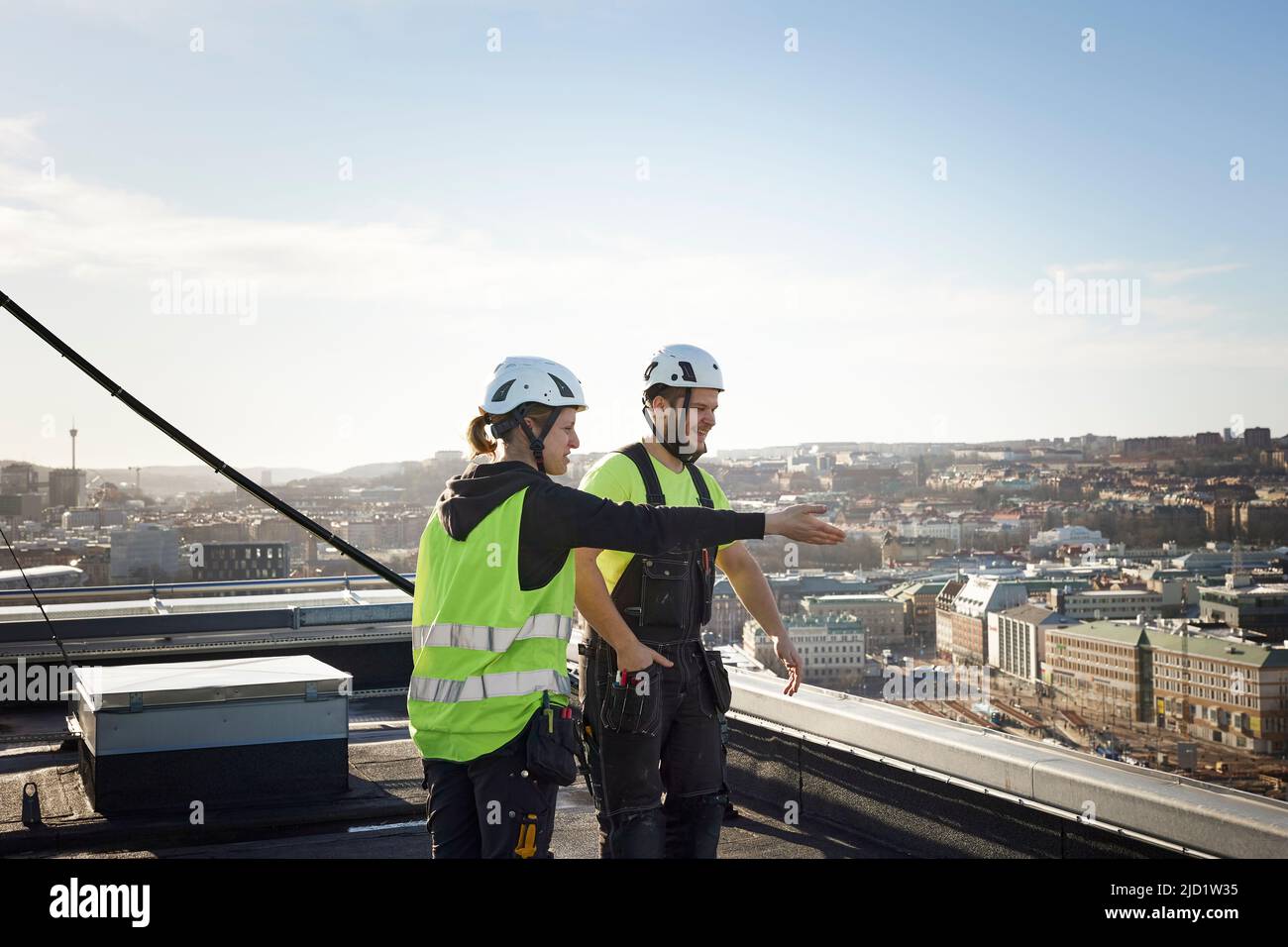 Workers standing on roof Stock Photo