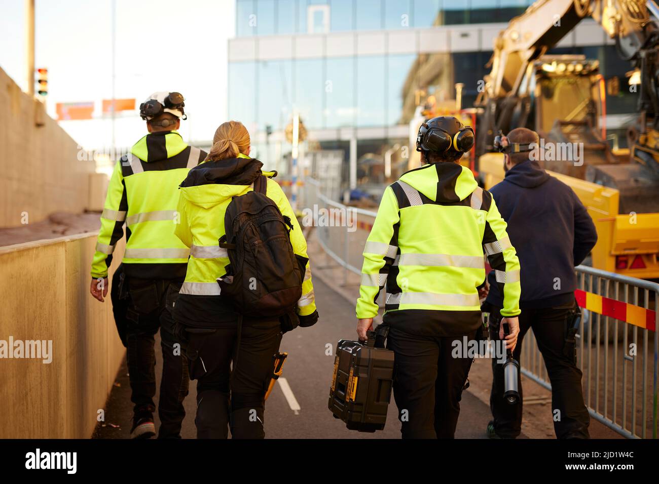 Rear view of workers at building site Stock Photo - Alamy