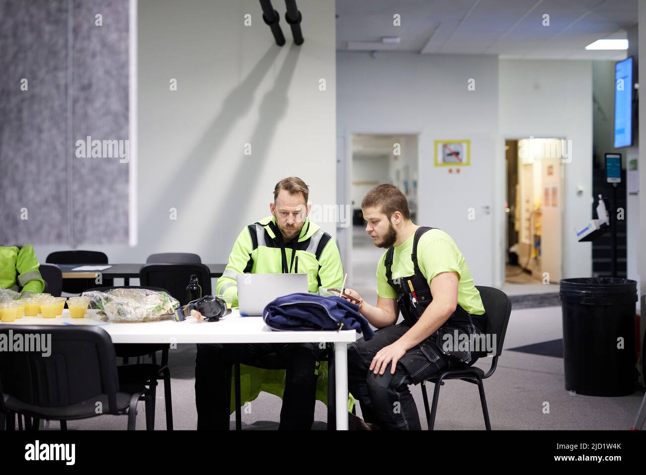 Workers in the canteen using laptop Stock Photo