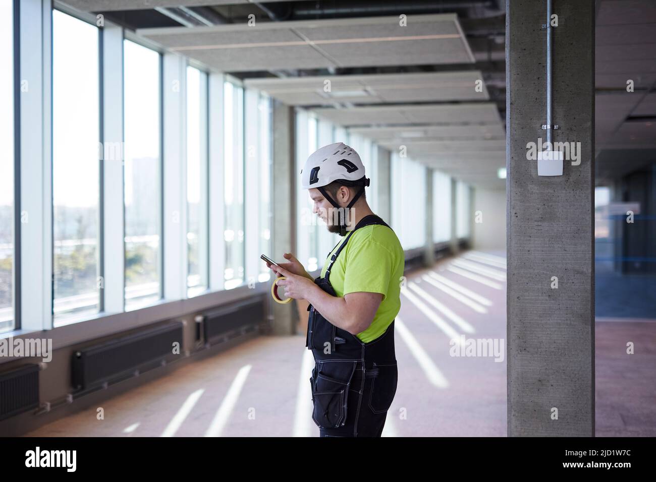 Worker using cell phone at building site Stock Photo