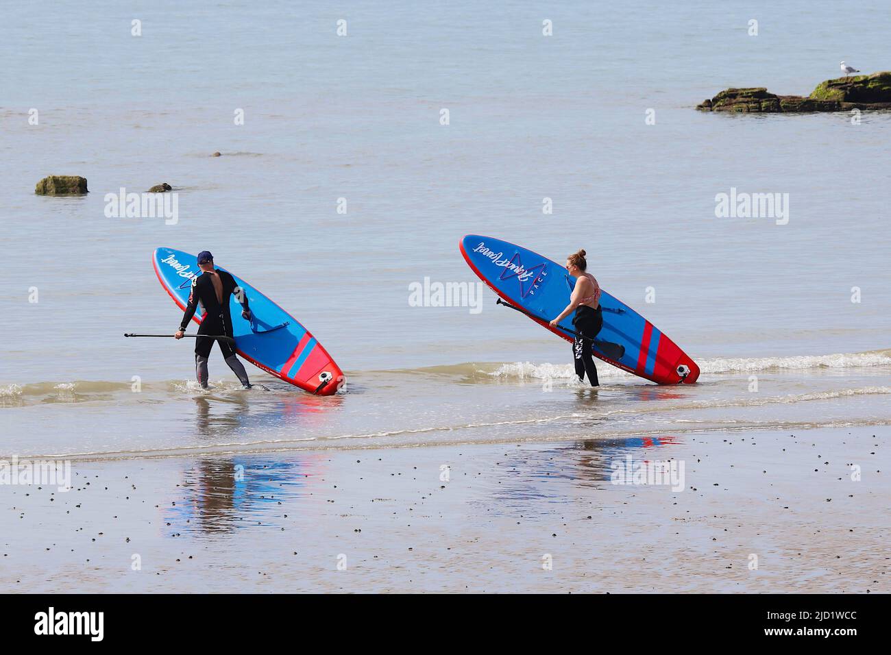Hastings, East Sussex, UK. 17 Jun, 2022. UK Weather: Very hot and sunny at the seaside town of Hastings in East Sussex as Brits enjoy the very hot weather today that is expected to reach 34c in some parts of the UK. A couple of paddle boarders head out to sea. Photo Credit: Paul Lawrenson /Alamy Live News Stock Photo