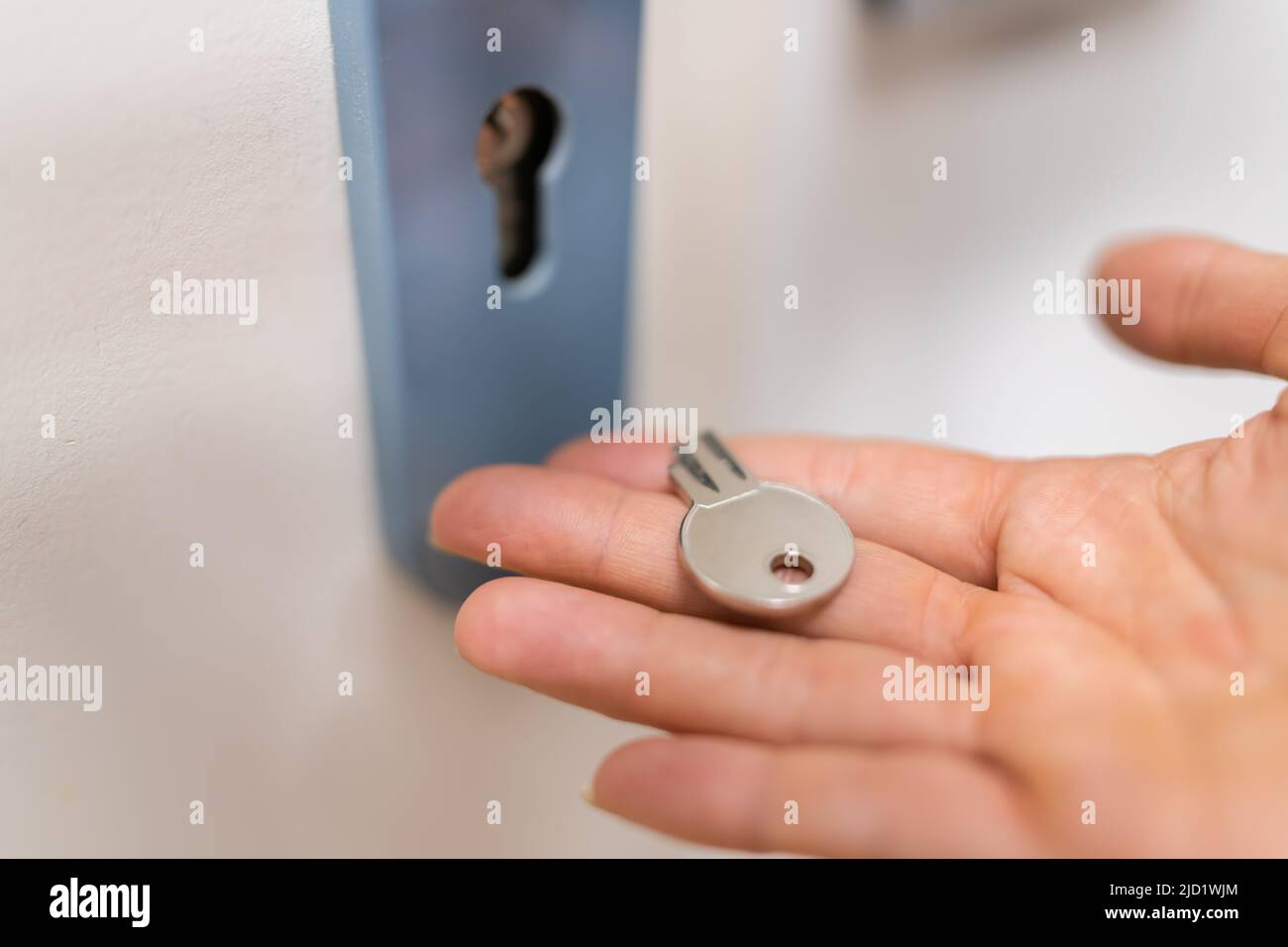 Close-up Of A Woman Holding Broken Key Near Keyhole Stock Photo