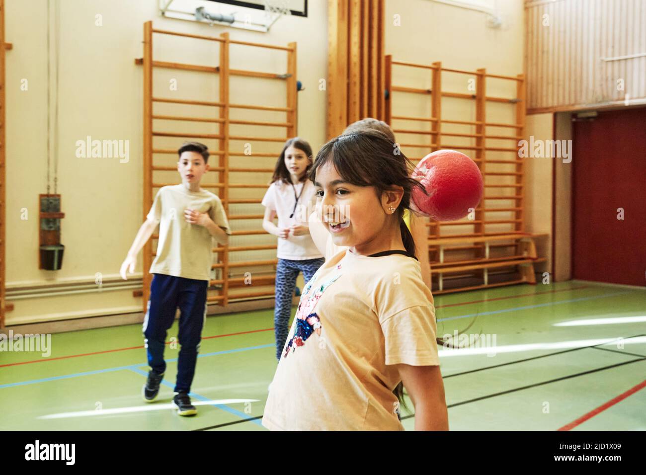 Girl throwing ball during PE class in school gym Stock Photo Alamy